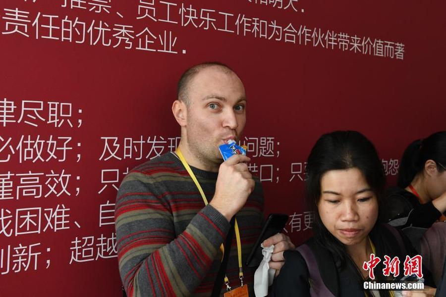 来自乌克兰《经济学家报》的BUZAROVANDRII在定兴县休闲食品小镇品尝喜之郎果冻。