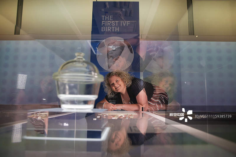 当地时间2018年7月23日，英国伦敦，世界首个试管婴儿路易丝·布朗出席科学博物馆展览，与她的胚胎使用过的玻璃干燥器合影，纪念世界上首个试管婴儿诞生40周年。1978年7月25日，世界上第一个试管婴儿路易丝·布朗在英国诞生，标志着人类在胚胎学上的重大进步。