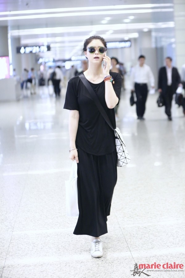百搭的小黑裙当然也适合运动鞋：
看似沉默的小黑裙搭配运动风平底鞋秒变Fashion Icon！时髦减龄的运动风混搭动感十足，夏日出街就该这样穿才吸睛。
蒋欣一身黑裙随团队现身机场。她戴拼色墨镜，身穿黑色圆领透视T恤，肩背Issey Miyake白色菱格纹邮差包，下穿黑色半身裙，脚踩Golden Goose星星印花白色休闲鞋。