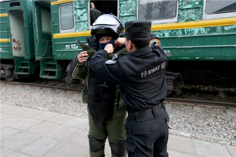 李刚在同事的帮助下穿上重达70斤的排爆服