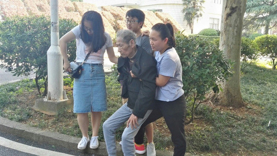 2017年5月26日，湖南长沙，湖南邮电职业技术学院内一名意识不清的老人摔倒在地，路过的一群学生连忙上前搀扶老人。