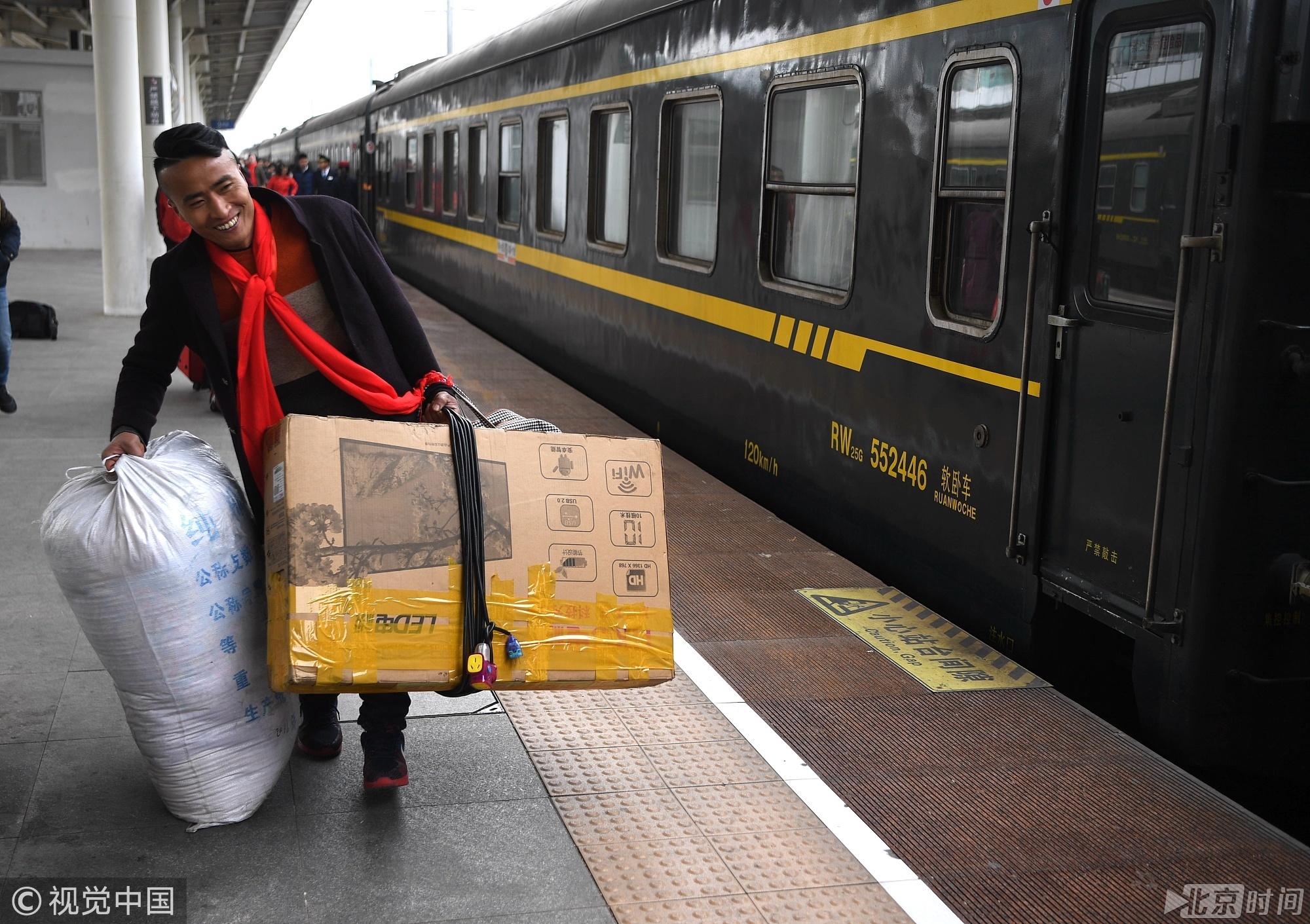 2018年2月7日，安徽阜阳。在深圳做生意的张松拎着彩电赶火车。安徽阜阳籍的张松带着全家老小乘坐由广东东莞开往安徽阜阳的K4698次列车，张松老家的房子已经盖好，这次回去就不打算回深圳了，家里的彩电、孩子的玩具扔了可惜就一起搬回家。  韩苏原(安徽分社)/中新社/视觉中国