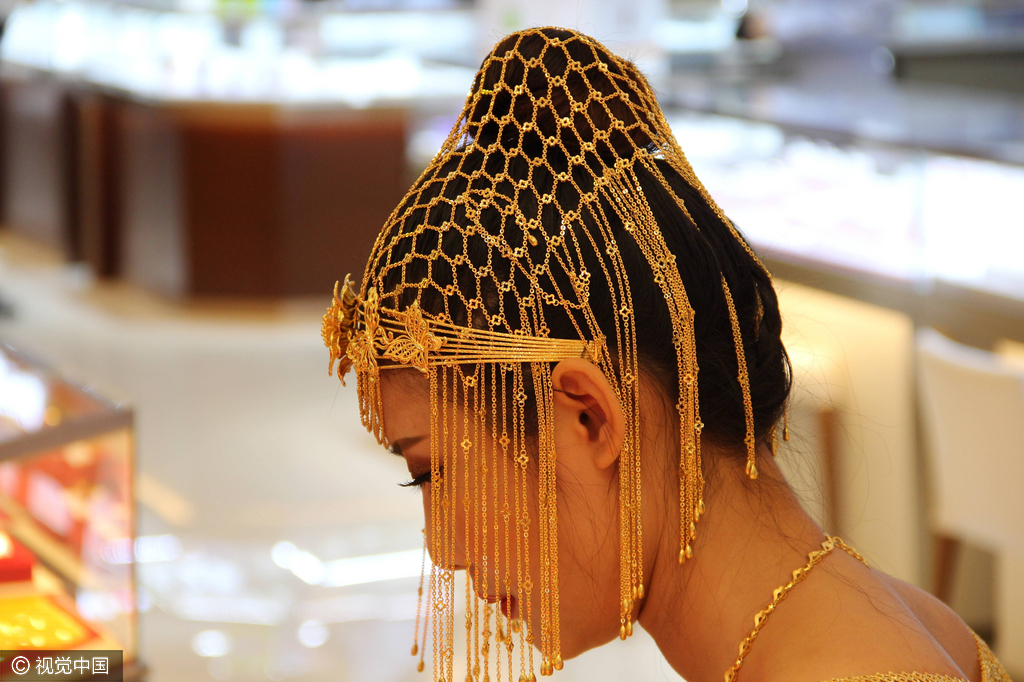 当日，山东滨州一广场举行开业典礼，邀请三名模特展示耗费9.9公斤黄金打造的价值360万天价婚纱。