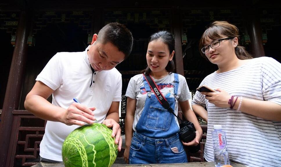 雕刻艺人在西瓜上作画。