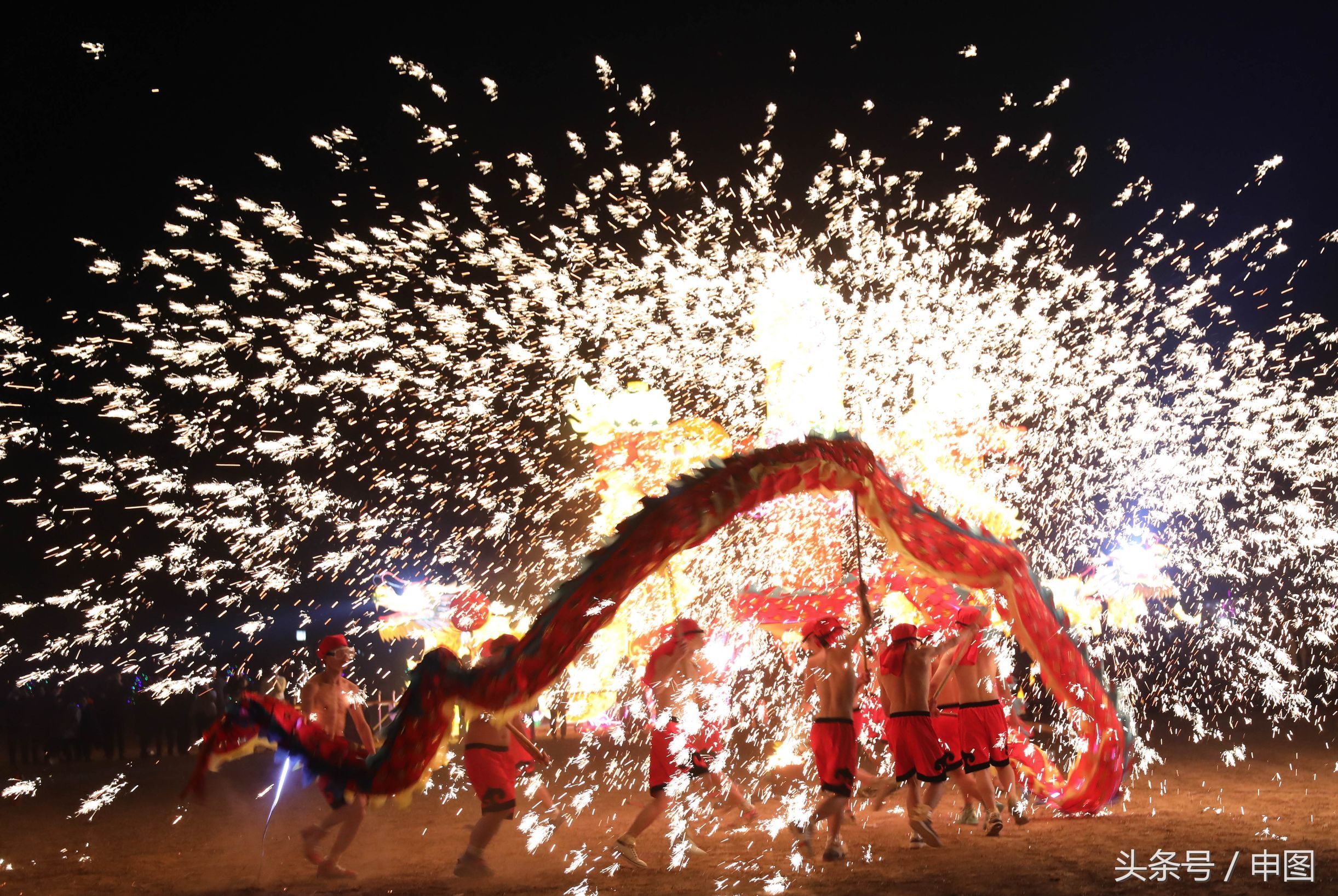 生铁在1500c化成铁水打在天空,小伙子光膀子在铁花火雨中舞龙