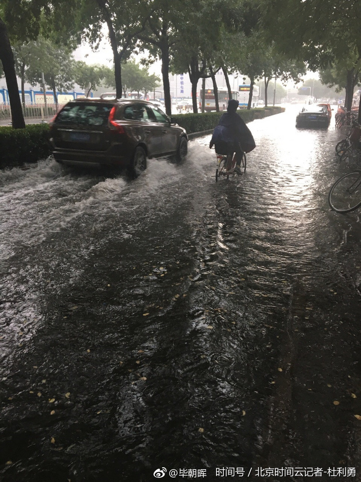 北京清晨现大雨 民众冒雨出行