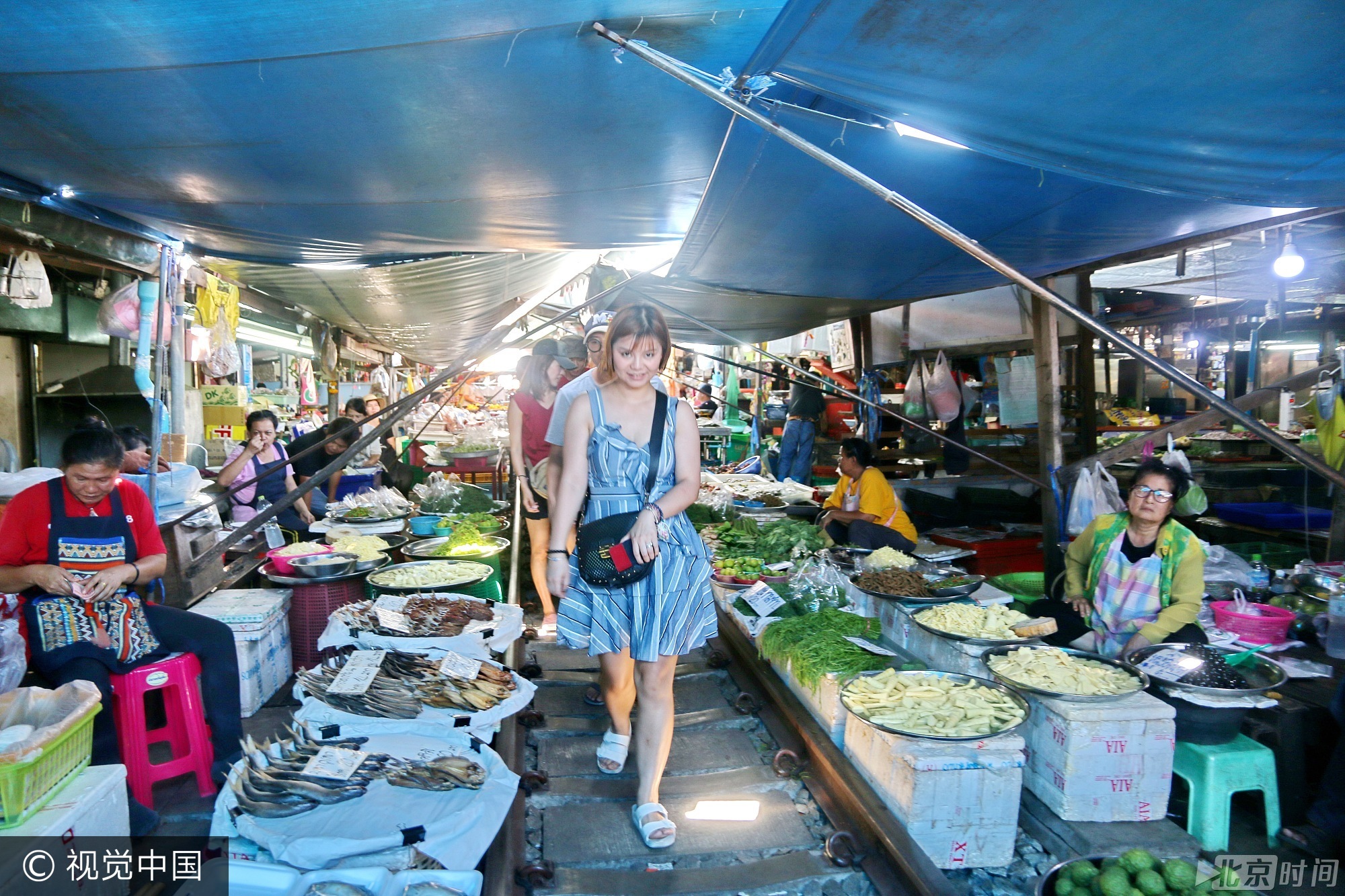 列车在摊位上驰来驰去，摊贩们早已经习以为常。