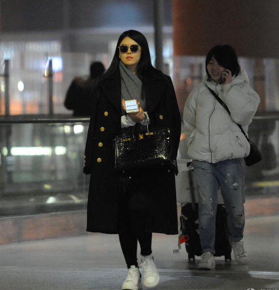 近日李湘抵达上海虹桥机场,当天李湘手挽名牌包出现,虽然一身黑装却