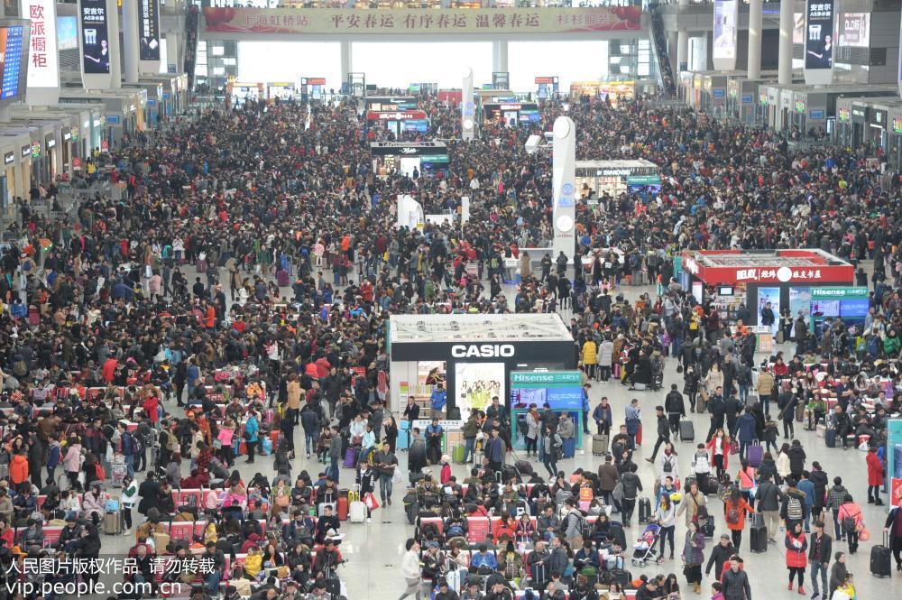 密密麻麻的旅客将上海虹桥火车站候车大厅挤得水泄不通,涌动的人潮似"