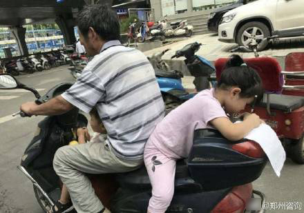 摩托车疾驰 后座女孩趴着做作业 摩托车疾驰 后座女孩趴着做作业