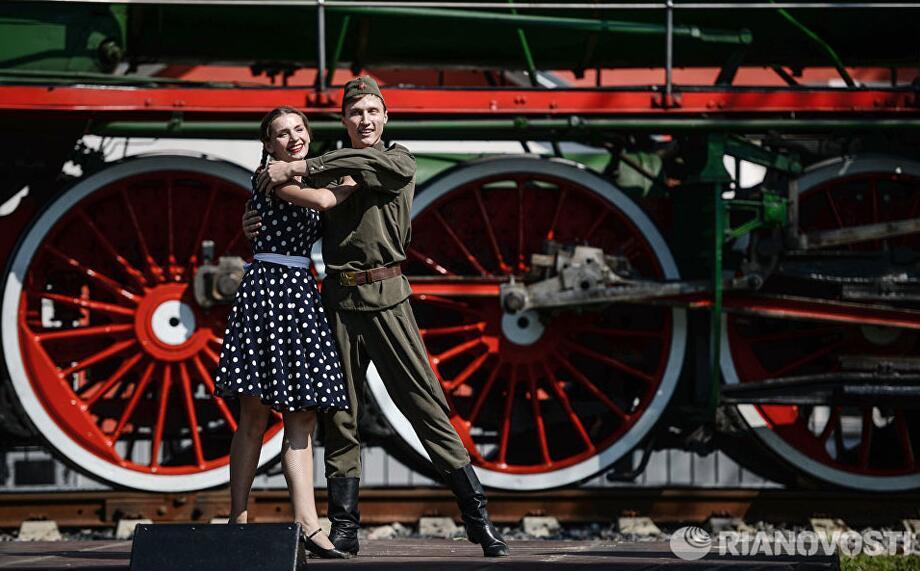 据俄罗斯媒体报道，8月8日是俄罗斯铁路工作者日。当天，莫斯科近郊举办了一场别开生面的蒸汽火车阅兵式。期间不仅展出了上世纪各个年代的蒸汽机车，还以戏剧表演的形式再现了蒸汽式火车为伟大卫国战争胜利立下的历史功勋。图为蒸汽机车阅兵式上的戏剧表演。