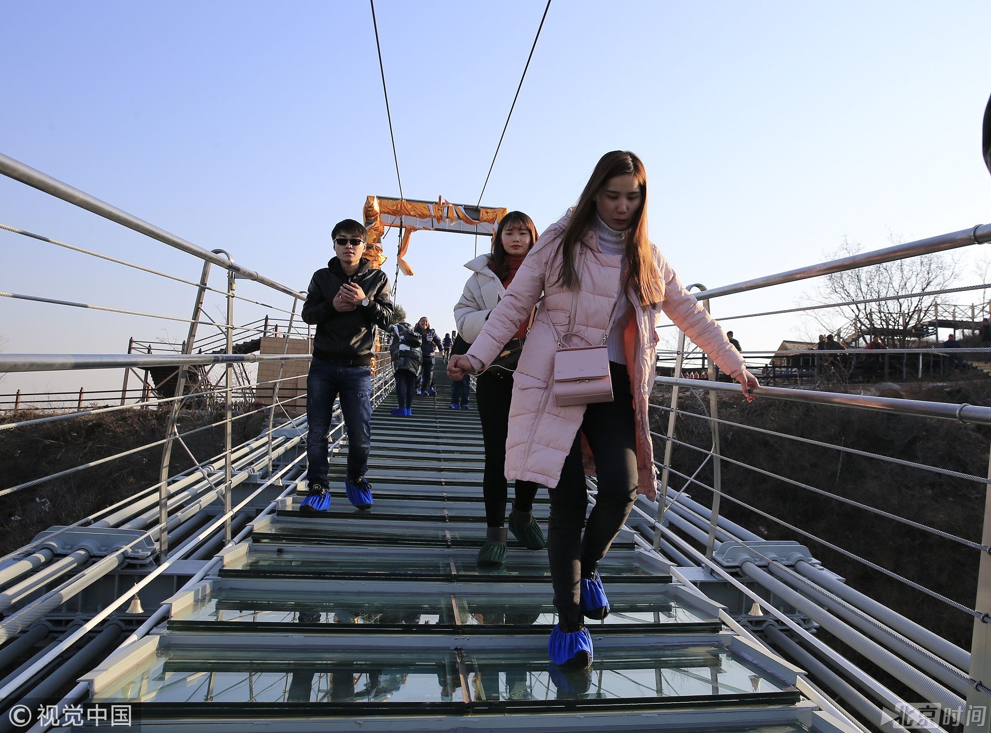 图为2017年12月26日，游客在红崖谷景区玻璃桥上行走体验。