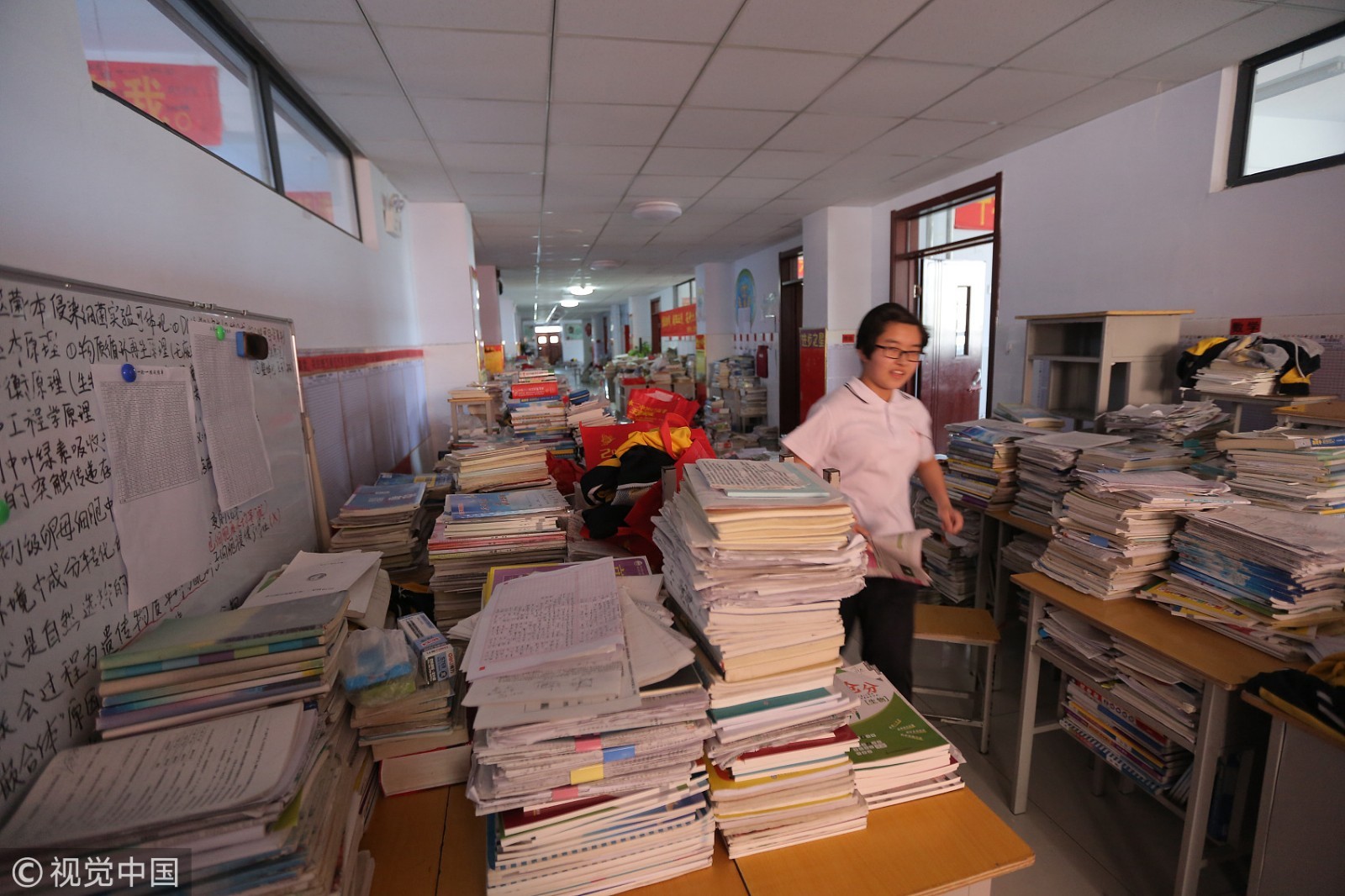 河北衡水二中高三教学楼内，最后一名学生从堆满课本及学习资料的楼道内跑着回宿舍。