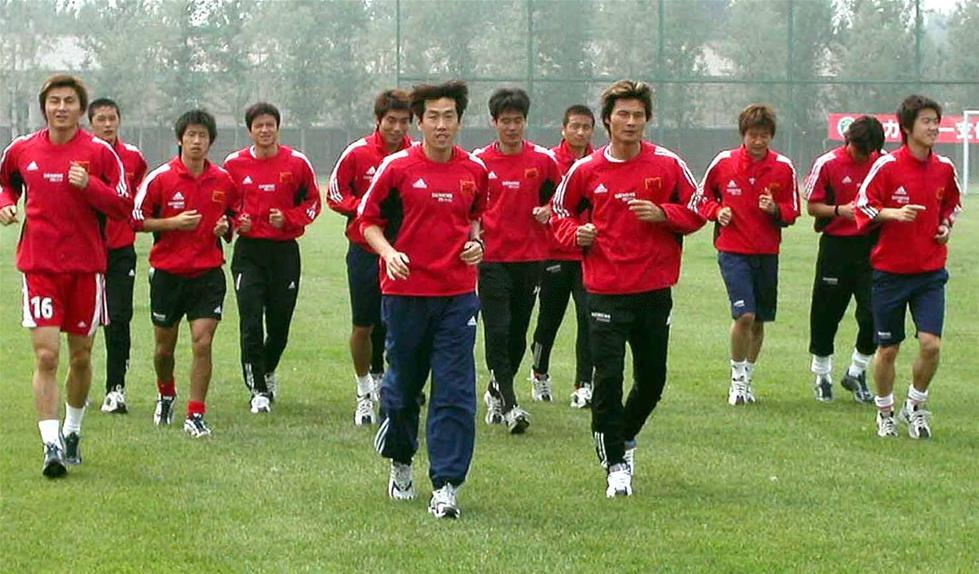 图为2003年5月12日，时任中国男足国家队助理教练的高洪波（前排左）带领队员在河北香河国家足球训练基地训练，备战东亚四强赛。新华社发