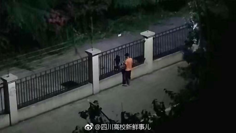 心酸的浪漫 两高校情侣隔着栅栏拥抱