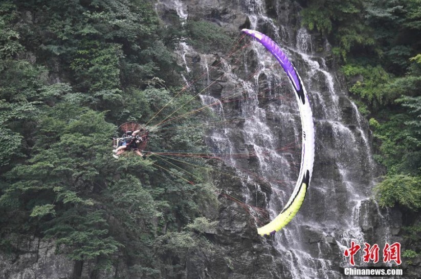 6月26日，参加“极限飞荡”张家界天门山动力伞特技国际大师赛的7名选手在湖南张家界天门山景区进行首轮试飞训练，吸引了众多游客驻足观赏。“极限飞荡”张家界天门山动力伞特技国际大师赛将于6月28日至29日在张家界天门山举行。