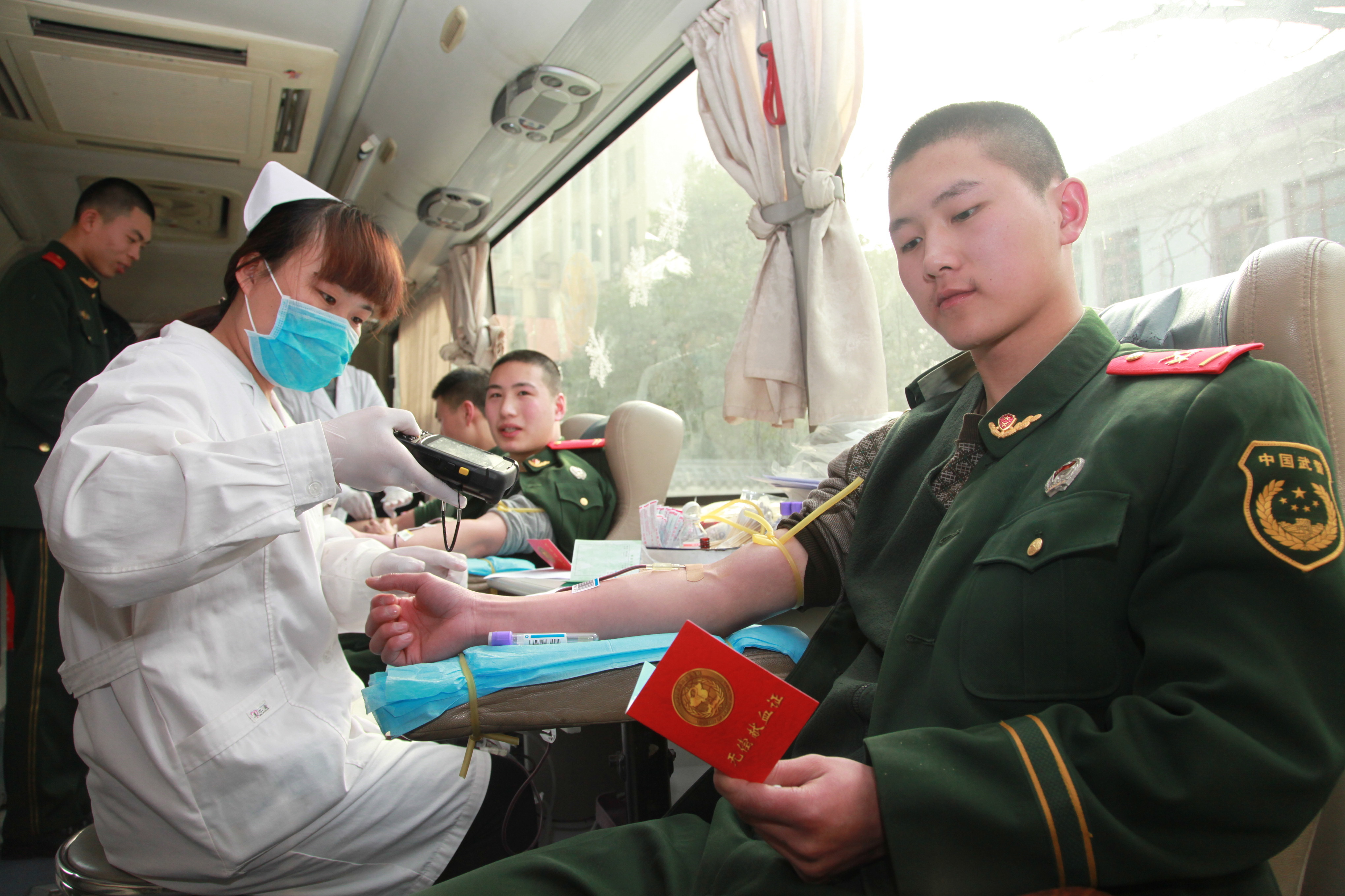 武警陕西省总队一支队把驻地当故乡、把人民当亲人,开展形式多样的爱民助民活动。图为战士们在进行义务献血。党忠斌摄