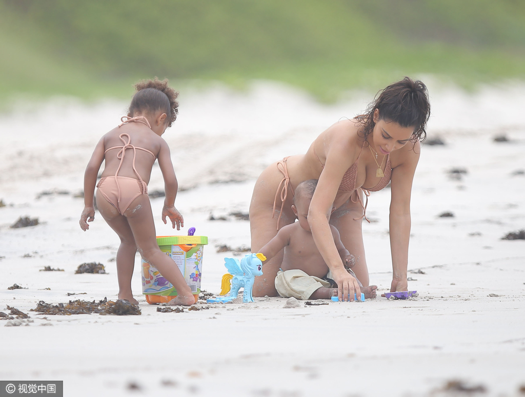 当地时间8月18日,金·卡戴珊(Kim Kardashian)带女儿小西北和儿子沙滩玩耍,卡戴珊身穿裸色系带比基尼,女儿与妈妈同款可爱十足,在沙滩上卡戴珊全程呵护幼子母爱爆棚,然而抢镜的还是翘臀。图为卡戴珊教幼子玩游戏。