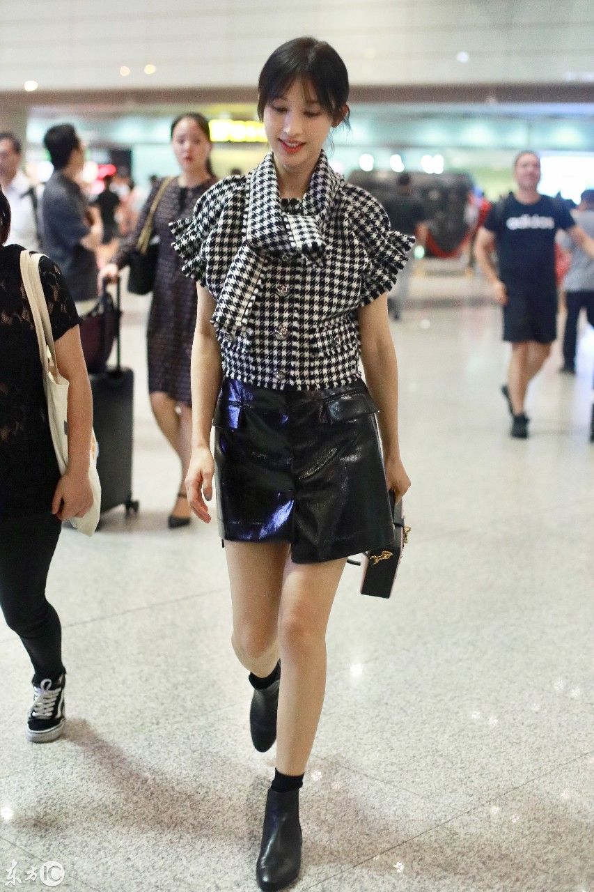 张俪现身机场,黑白格子上衣配黑色皮裙,简单又