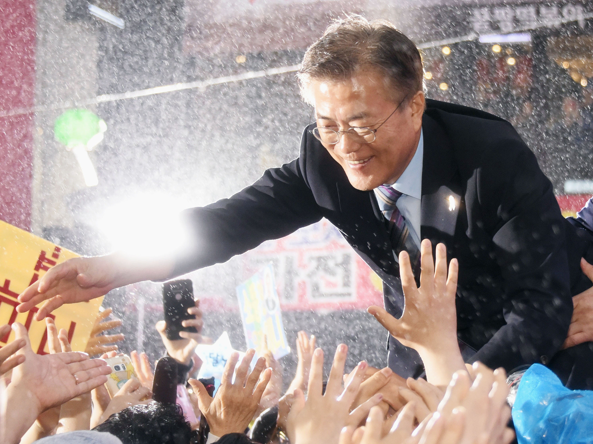 当地时间2017年5月5日，韩国釜山，文在寅为韩国总统选举造势，冒雨与支持者互动。