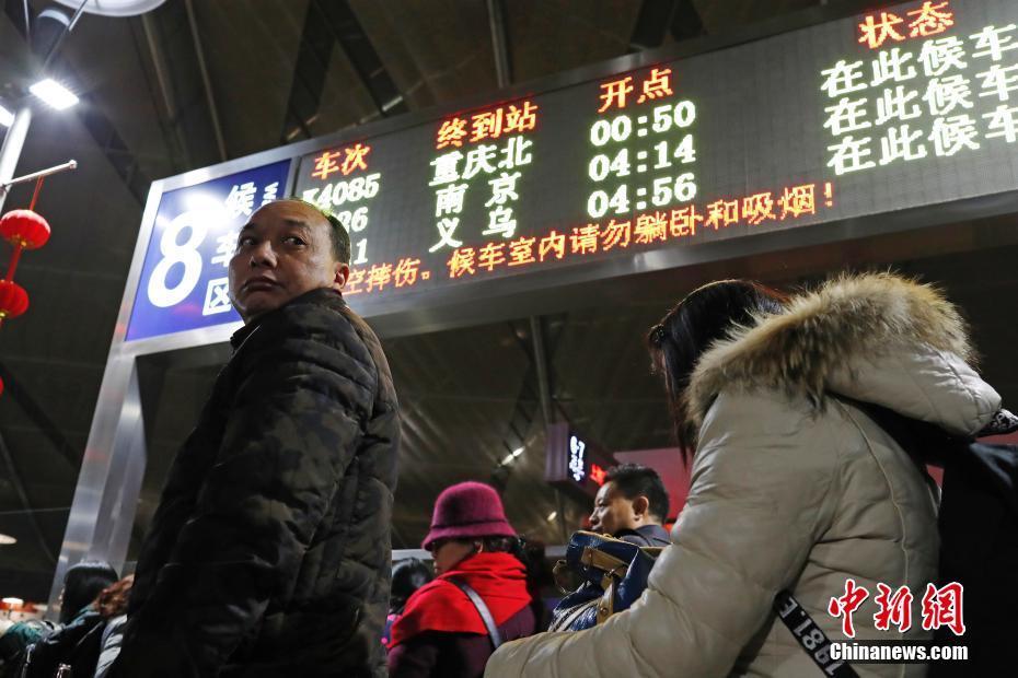 在铁路上海南站，返乡的旅客大包小包的等待着检票。