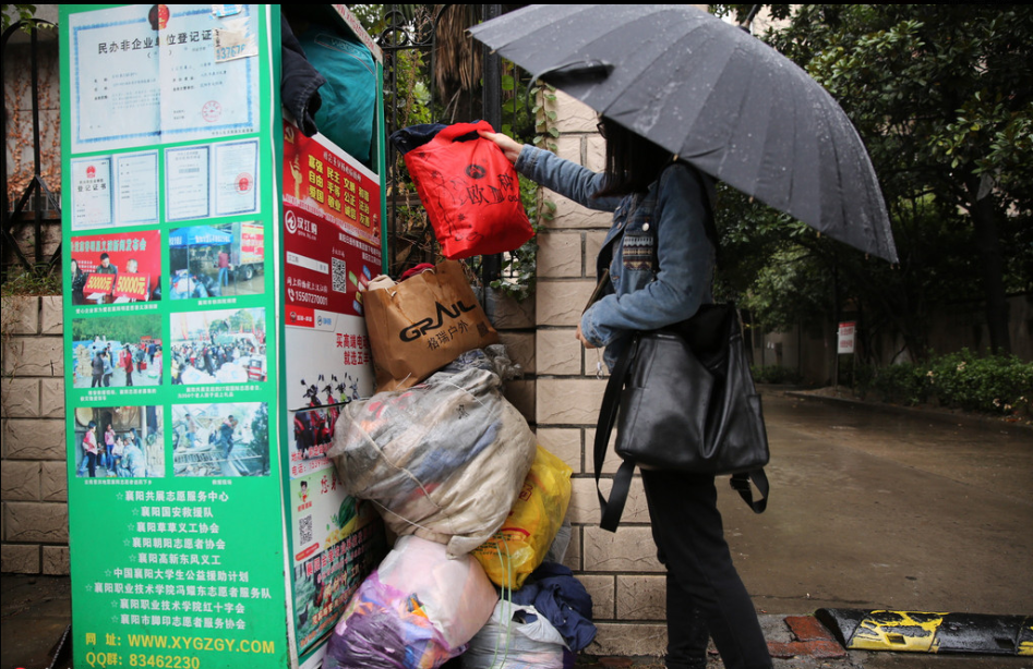 2016年10月13日，湖北省襄阳市，旧衣回收箱已经堆满，回收箱外还摆着许多旧衣。摄影来源：中国日报网