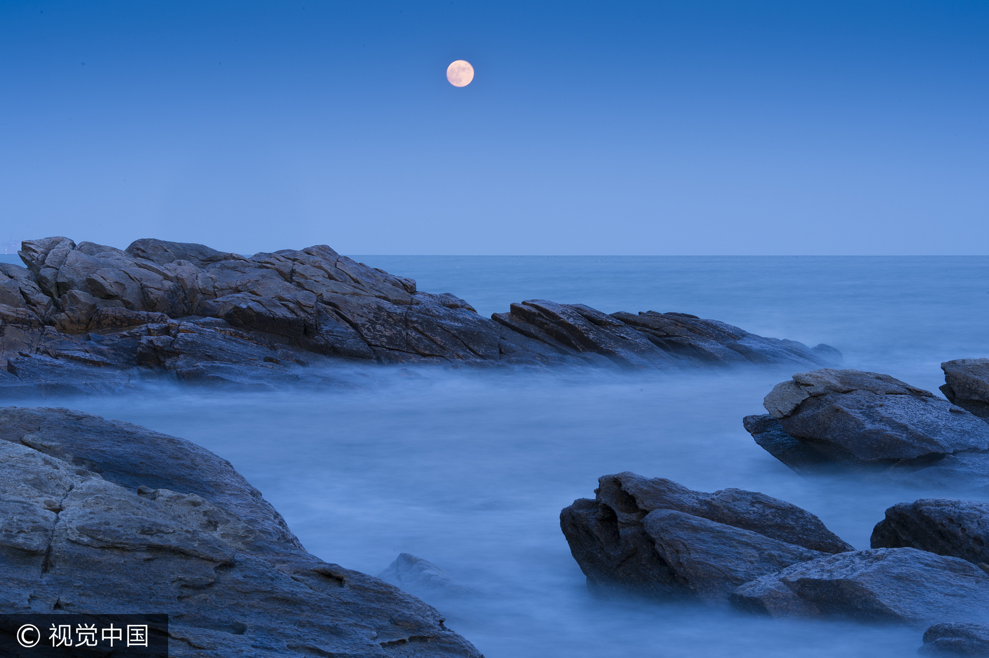 2013年11月17日，山东省日照市，一轮明月从海上跃出。（二次曝光）