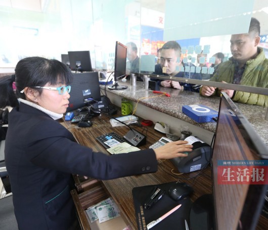 西乡塘客运站的一名售票员正在售票.记者 何学俏 摄