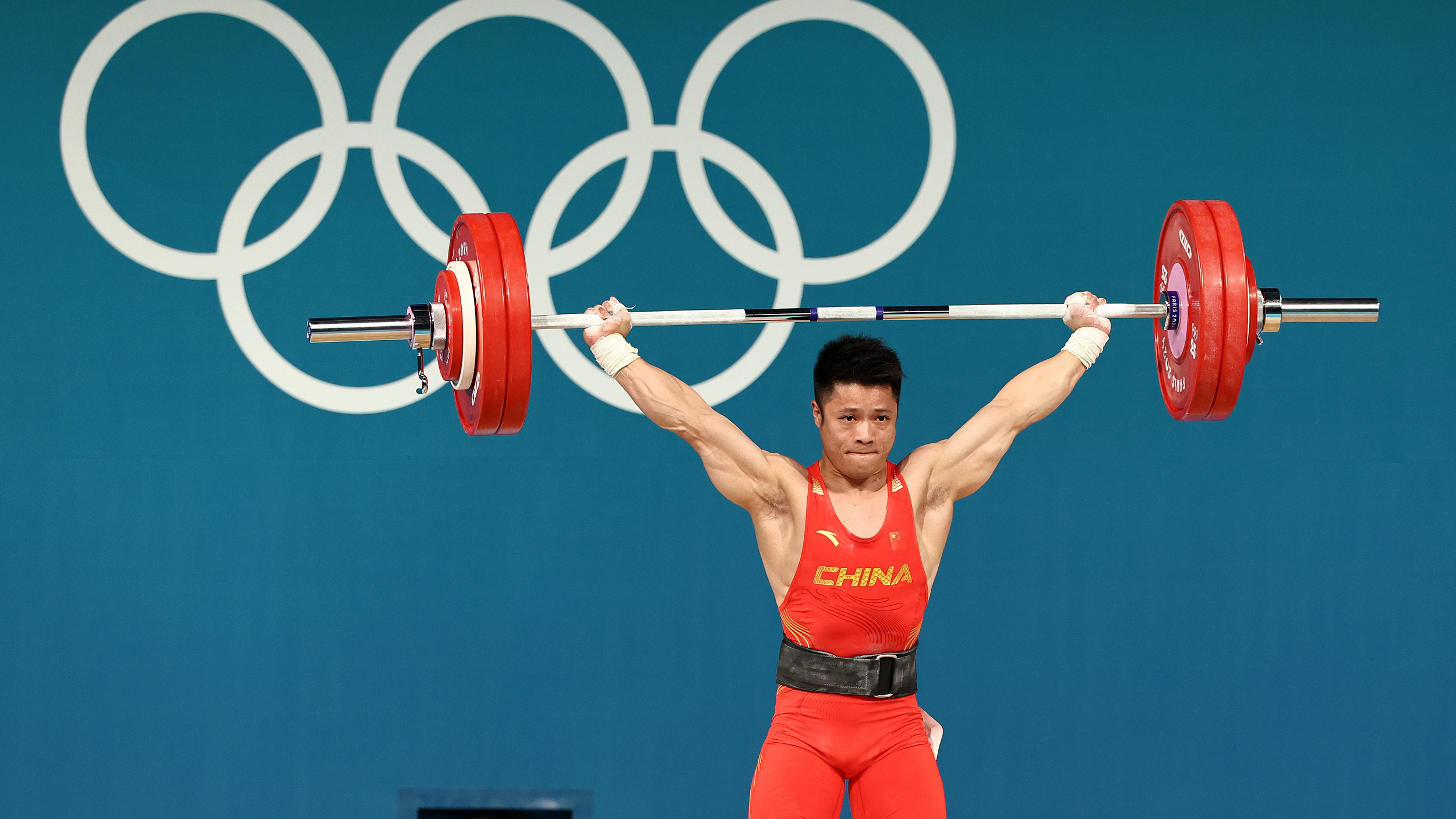 “中国力量”征服奥运赛场！李发彬卫冕举重男子61公斤级冠军
