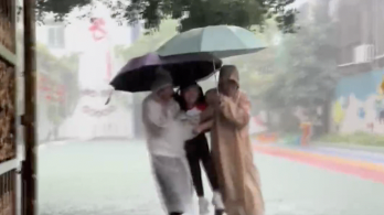 暴雨天放学老师把孩子“架起来”护中间 送出校门
