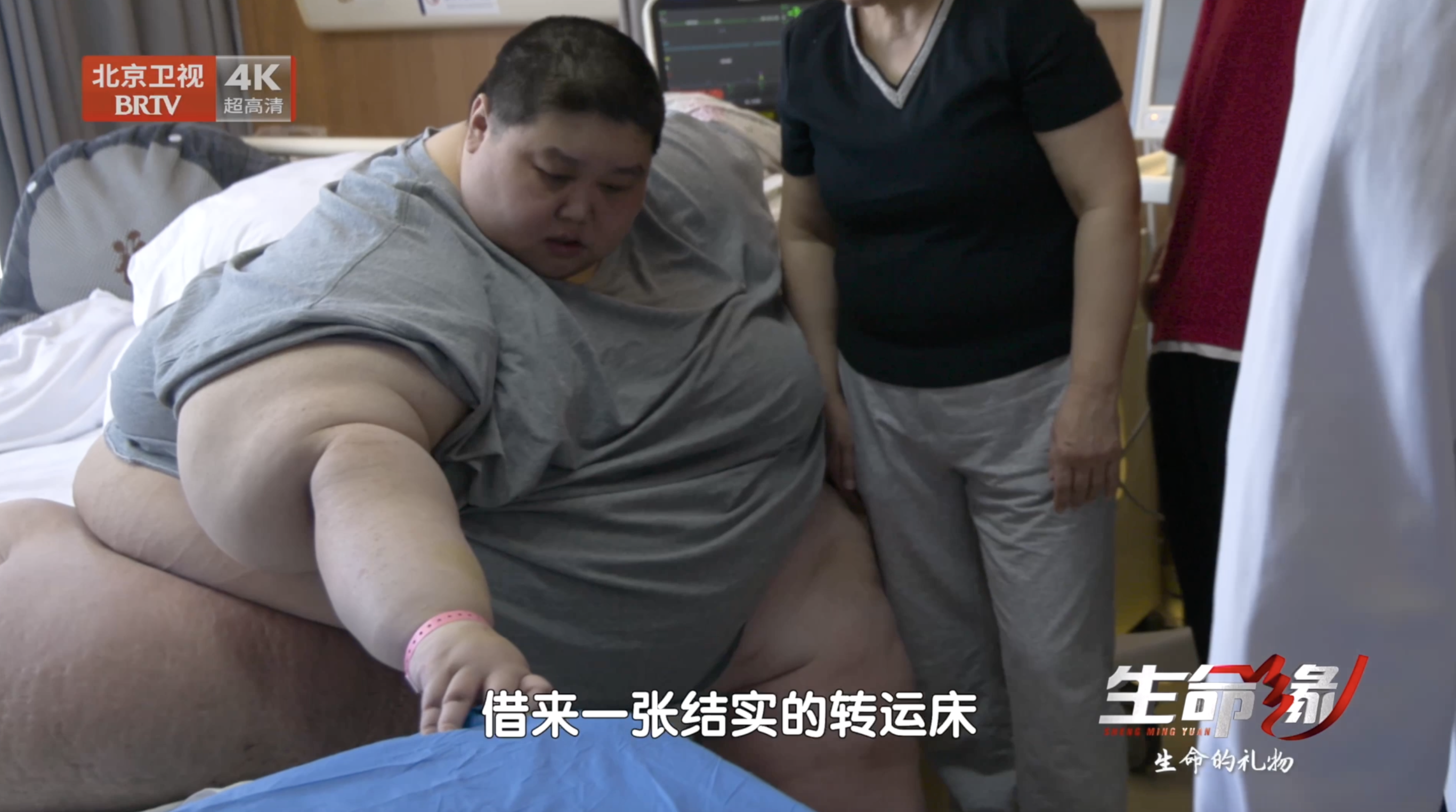 为尽快称出杨铭准确体重、精准用药，杨铭尝试扶着一张结实的床站在体重秤上称重（13）
